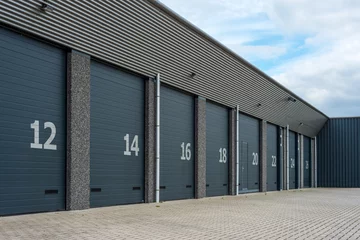 Runde Acrylglas-Bilder Industriegebäude Reihe von grau nummerierten Geschäftseinheiten oder Garagen
