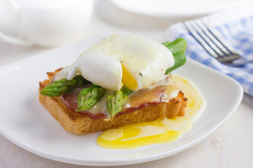 Eggs Benedict with hollandaise sauce on toast with  bacon and as