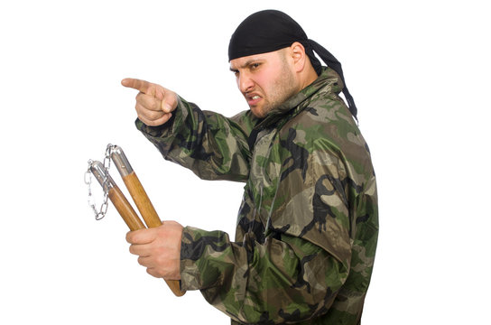 Young man in soldier uniform holding nunchaks isolated on white