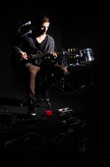 Fototapeta na wymiar Man playing guitar in dark room