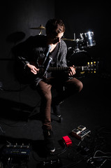 Man playing guitar in dark room