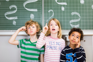 Kinder nachdenklich an der Tafel Schule 