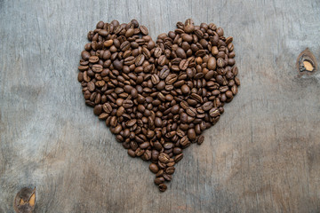 Heart of coffee beans on wooden background