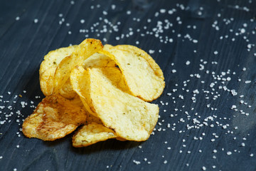 Potato chips and sprinkled salt, selective focus