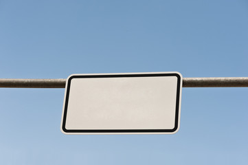 Ein unbeschriftetes weisses Schild unter blauem Himmel