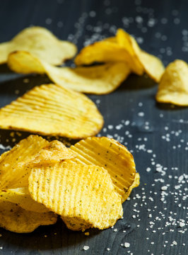 Potato chips and sprinkled salt, selective focus