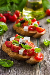 bruschetta with tomato, feta cheese, olives and basil