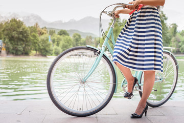 beautiful woman dressed in fashion dress travel by vintage bicycle