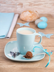 Cup of tea on wooden table with Easter decorations