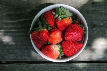 Strawberries in the bowl on wooden table