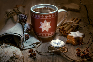 Steaming mug of tea with winter decorations
