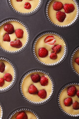 raw strawberry muffins in baking dish vertical top view 
