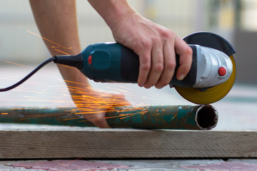 Man cuts a metal pipe cutting machines