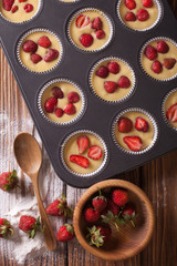 cooking muffins with fresh strawberries vertical top view
