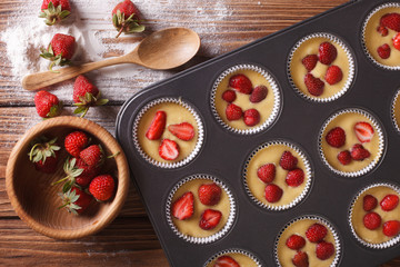 cooking muffins with fresh strawberries horizontal top view
