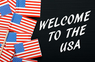 Welcome to the USA written on a blackboard with flags