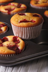 muffins with fresh strawberries close up in baking dish. vertical
