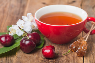 black english tea in red cup with cherry