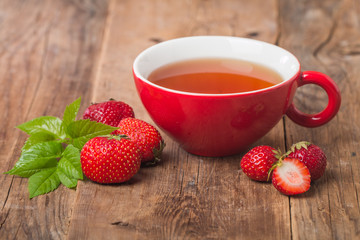 black english tea in red cup with strawberry