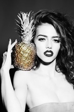 Magnificent young girl with golden pineapple