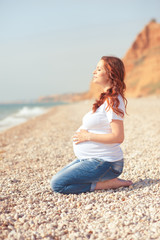 Fototapeta na wymiar Pregnant girl at seashore