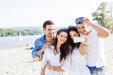 Group of cheerful and beautiful young people taking photos of th