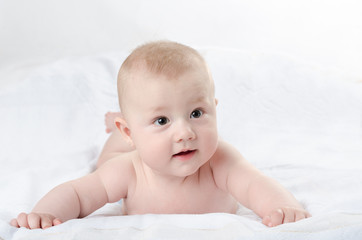 happy baby lying on a white rug