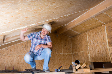 Fototapeta premium Builder on Scaffolding in Unfinished House