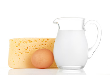 Big piece of cheese, glass jug with milk