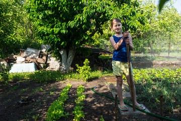 Girl Standing in Vegetable Garden with Hoe