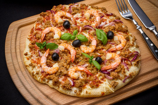 Tuna pizza with shrimp and olive, cutlery