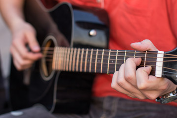 Obraz na płótnie Canvas young man playing an acoustic guitar on the beach