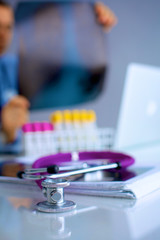 Medical doctor  sitting at table and looking patients roentgen