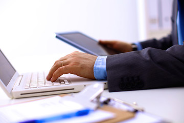 Businessman sitting in office, working with laptop computer