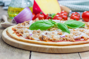 Pizza with tuna fish on a wooden board