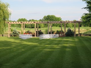 White empty chairs set for outdoor wedding ceremony