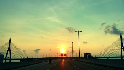 Obraz premium Sunrise between bridge and road