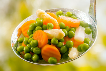 Ladle of boiled freshly harvested young vegetables