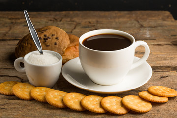 Cup of coffee on a wooden board and biscuits