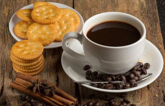 Cup of coffee on a wooden board and biscuits