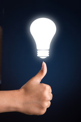 Thumbs up with glowing bulb - concept for idea and success