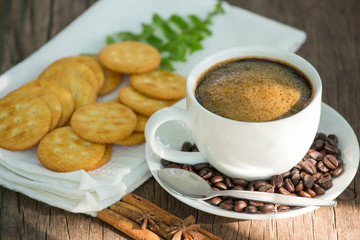 Cup of coffee on a wooden board and biscuits