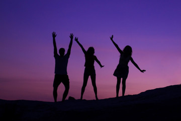 Silhouettes of friends on the sunset.