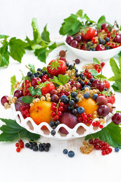 dish with fresh seasonal fruit and berries, vertical