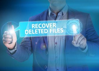 Businessman presses button recover deleted files on virtual scre
