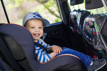 portrait happy toddler boy  in the car