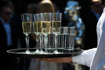 Champagne waiter carries on a tray