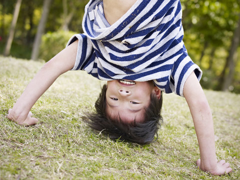 asian child standing on hands outdoors
