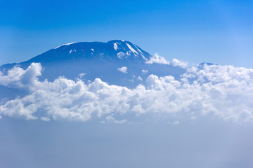 View of Mount Kilimanjaro from Mt Meru, Tanzania in Africa. Clouds surrounding the mountain. - obrazy, fototapety, plakaty