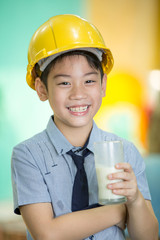 Young asian child holding a glass of milk